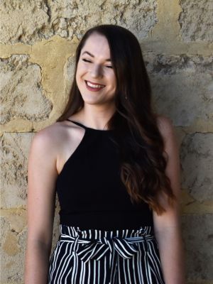 Image of Carolyn Wilkinson smiling with a limestone wall in the background.